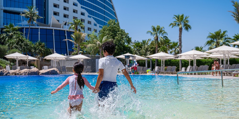 Jumeirah Beach Hotel Dubai wave-shaped resort with family pool, private beach and Burj Al Arab in background