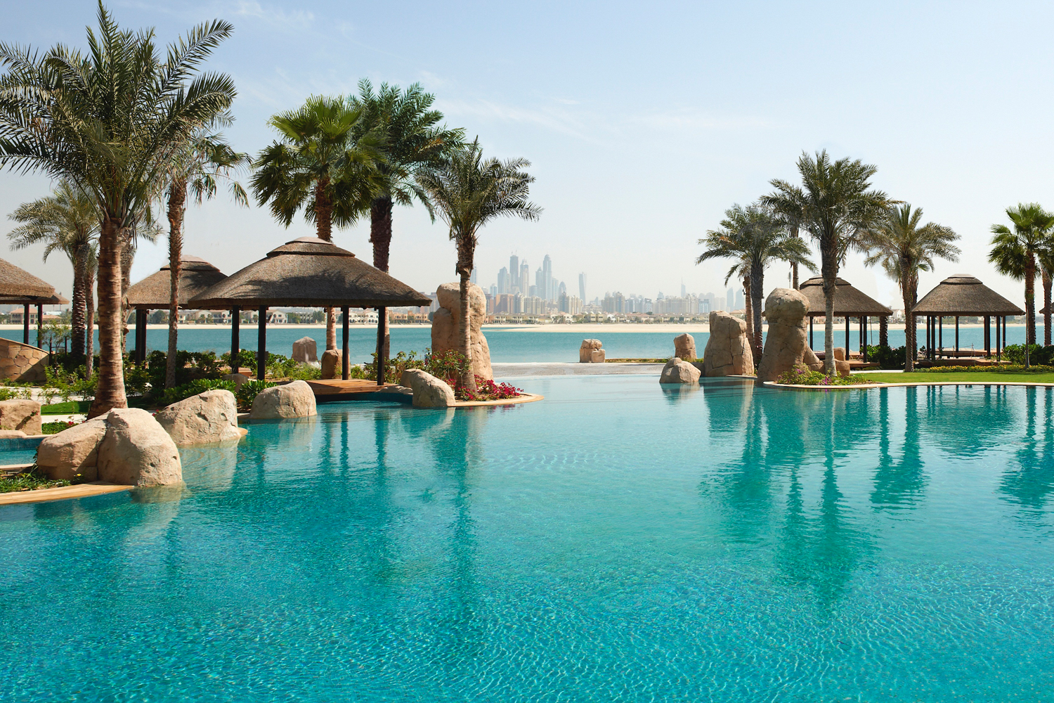 Sofitel Dubai The Palm beach club with lagoon pool and Arabian Gulf at sunset